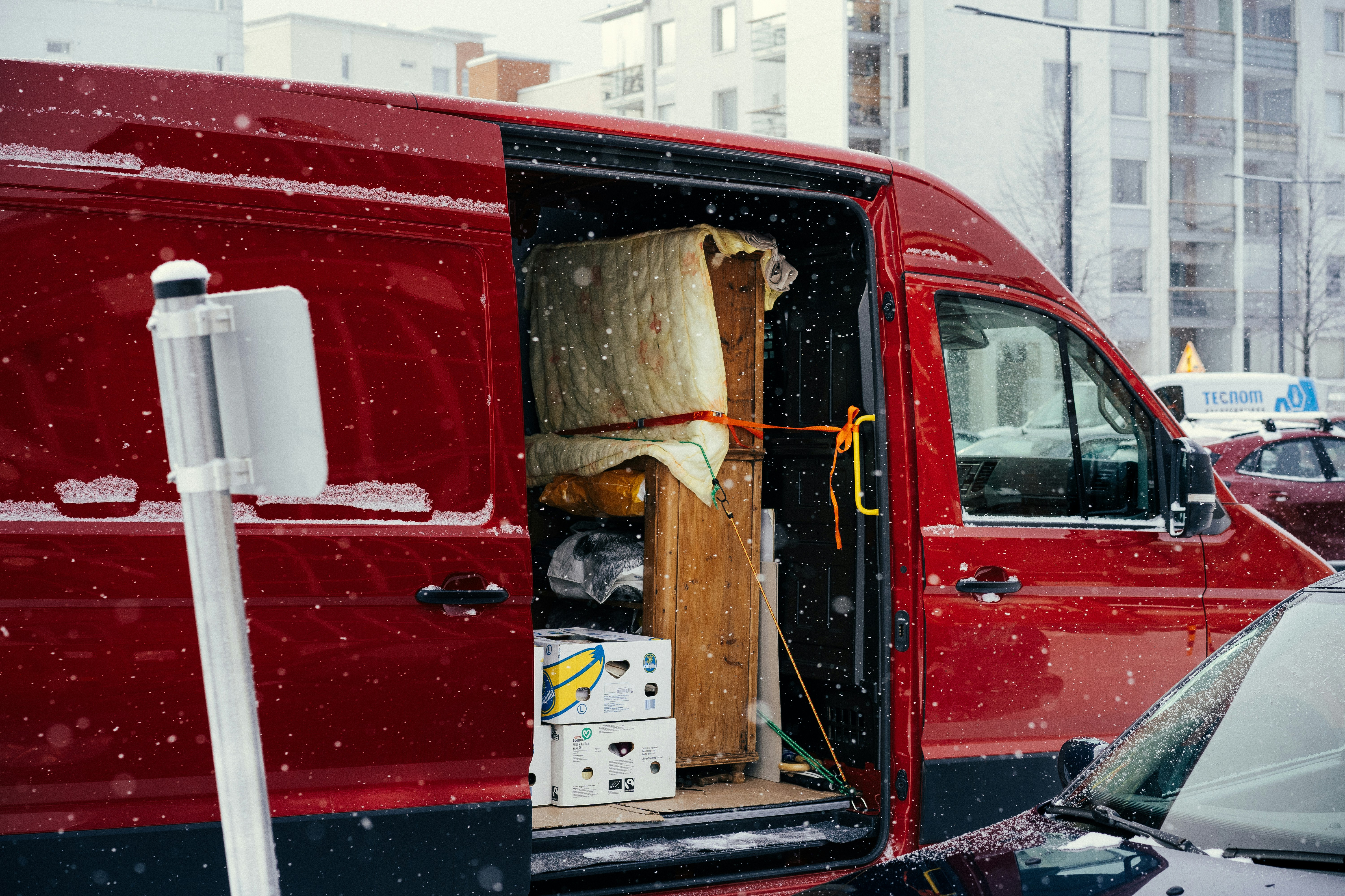Prenajatá dodávka s otvorenými dverami, v ktorej je naložený nábytok pripravený na vyloženie alebo prevoz.
